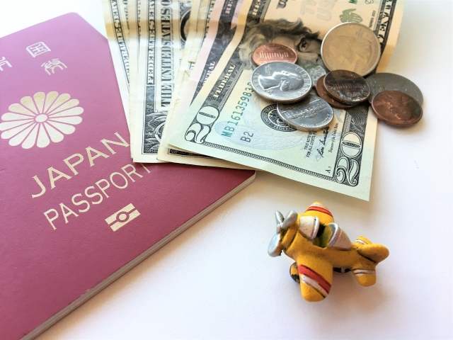 海外の紙幣・コインとパスポート、ミニチュアの飛行機