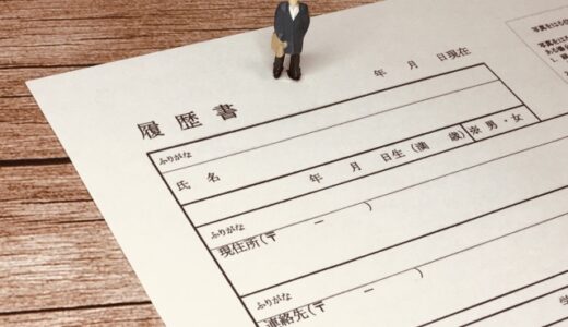 履歴書の上に立つ男性の人形