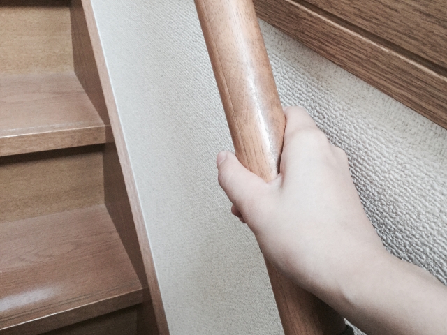 階段の手すりをつかむ手
