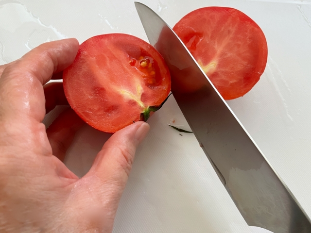 包丁でトマトを切る様子