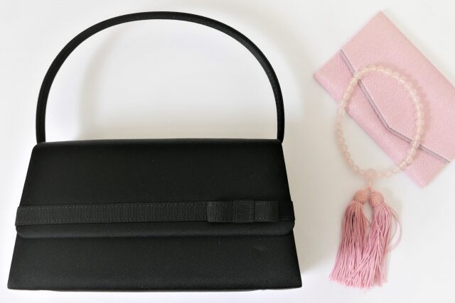 黒のフォーマルバッグとピンクの数珠