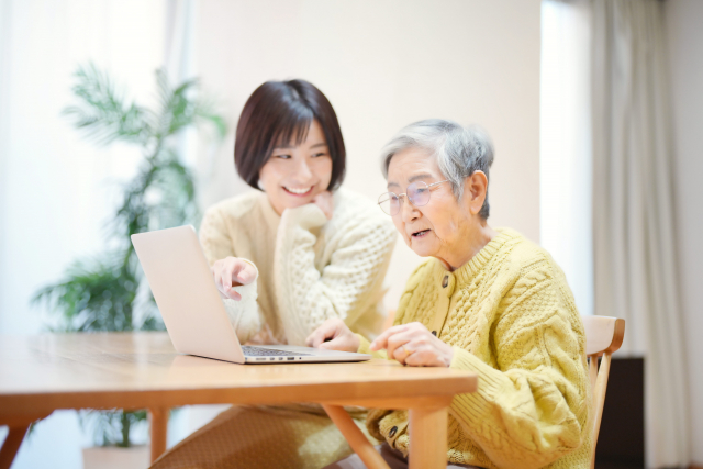 パソコンを見る祖母と孫
