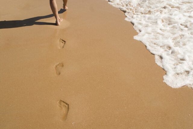 波打ち際を裸足で歩く足跡